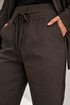 Dark brown pants with a drawstring waist on a light gray background