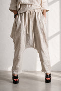 Person wearing beige wide-leg pants with a white background