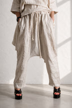 Person wearing beige wide-leg pants with a white background