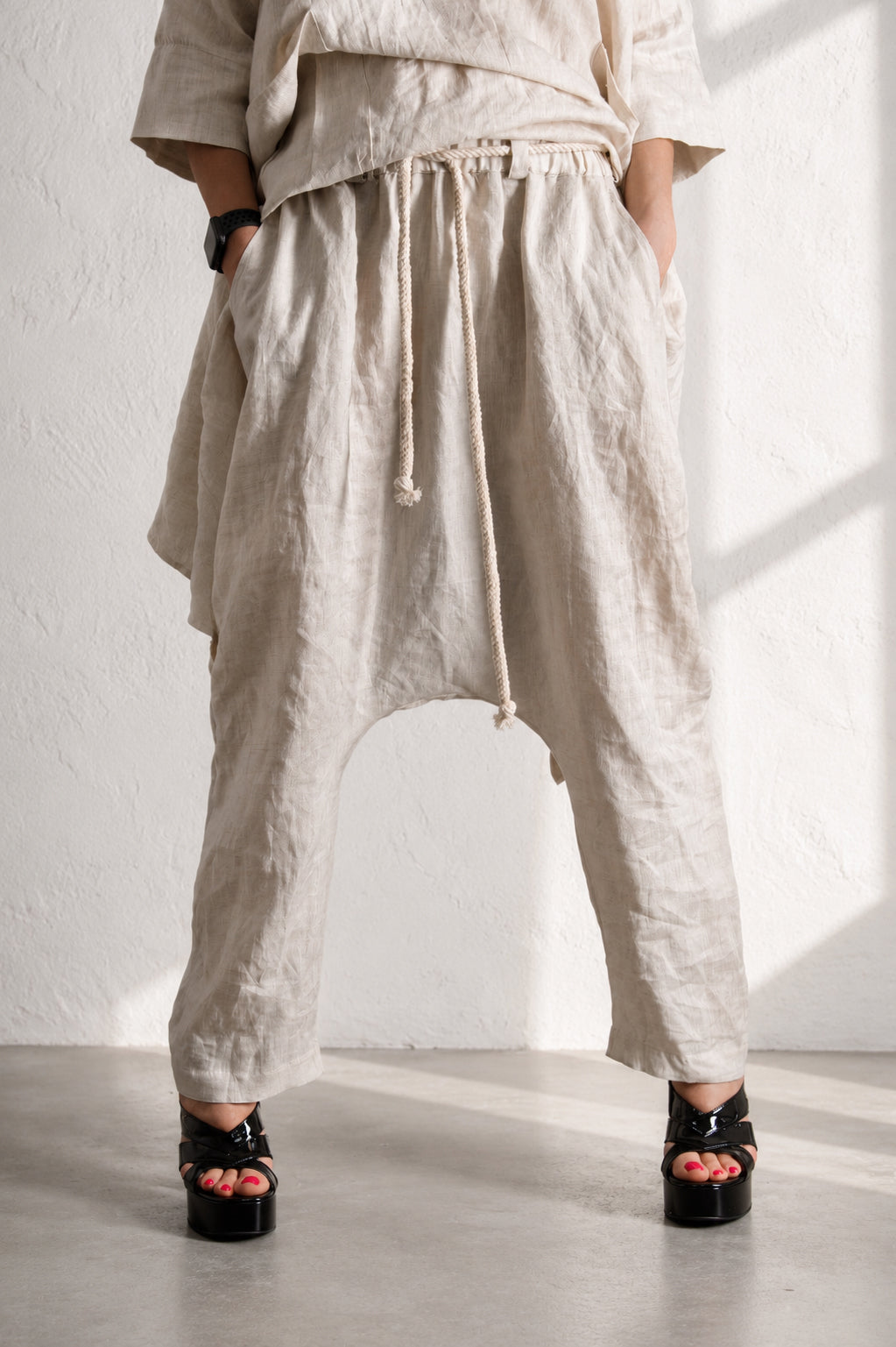 Person wearing beige wide-leg pants with a white background