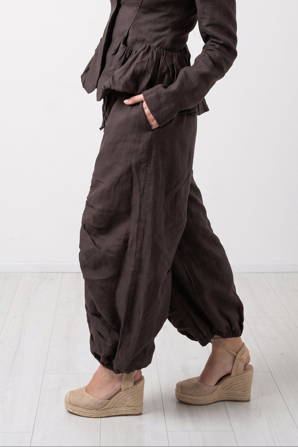 Woman wearing a brown jumpsuit on a white background
