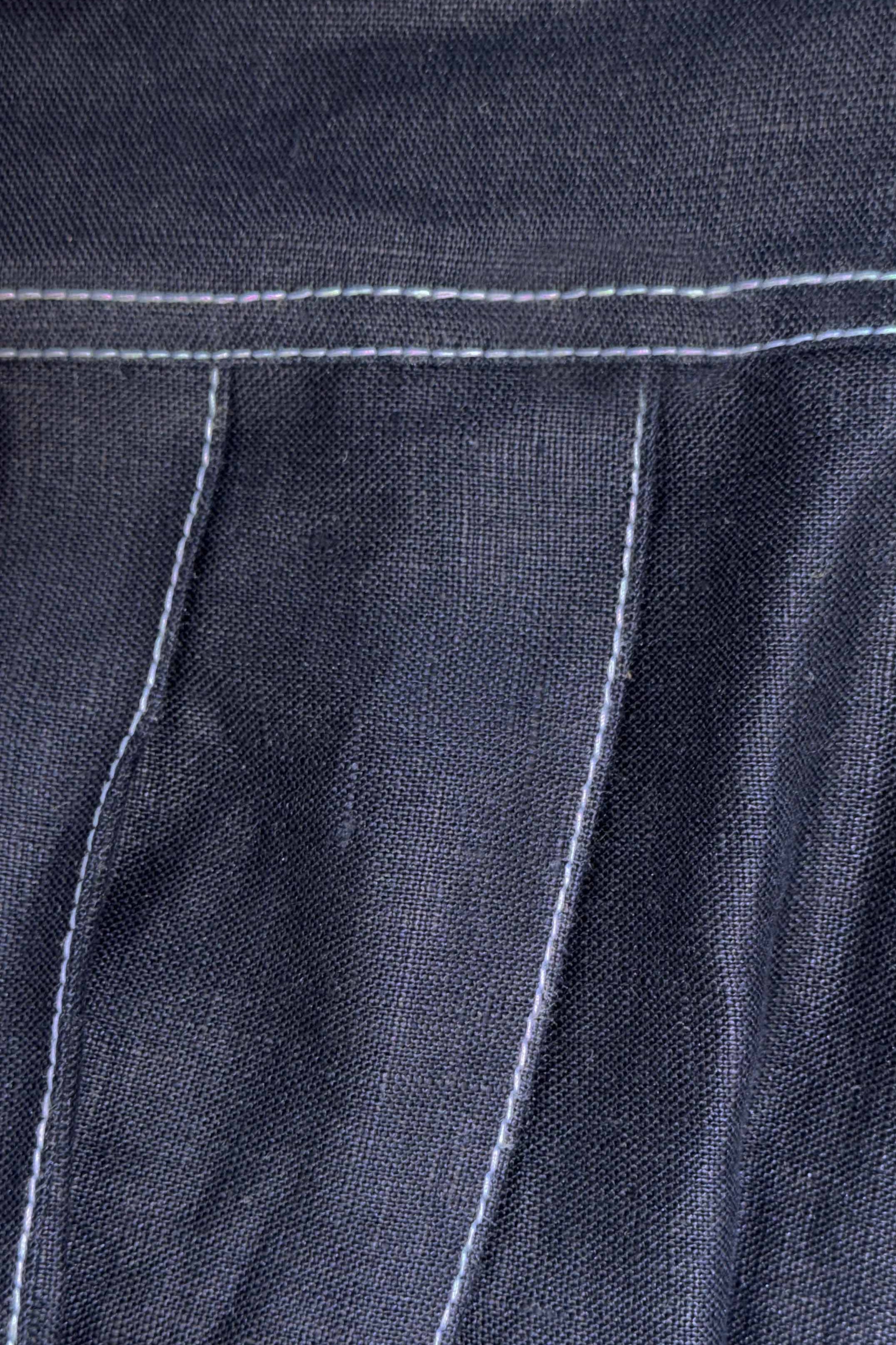 Close-up of dark denim fabric with white stitching
