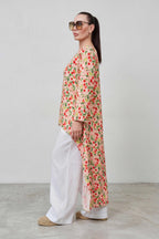 Woman wearing a floral dress and sunglasses against a plain background
