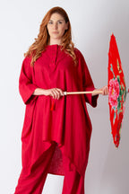 Woman in a red outfit holding a decorative umbrella against a white background