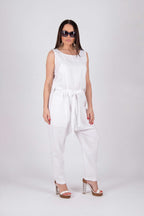 Woman wearing a white sleeveless jumpsuit on a white background