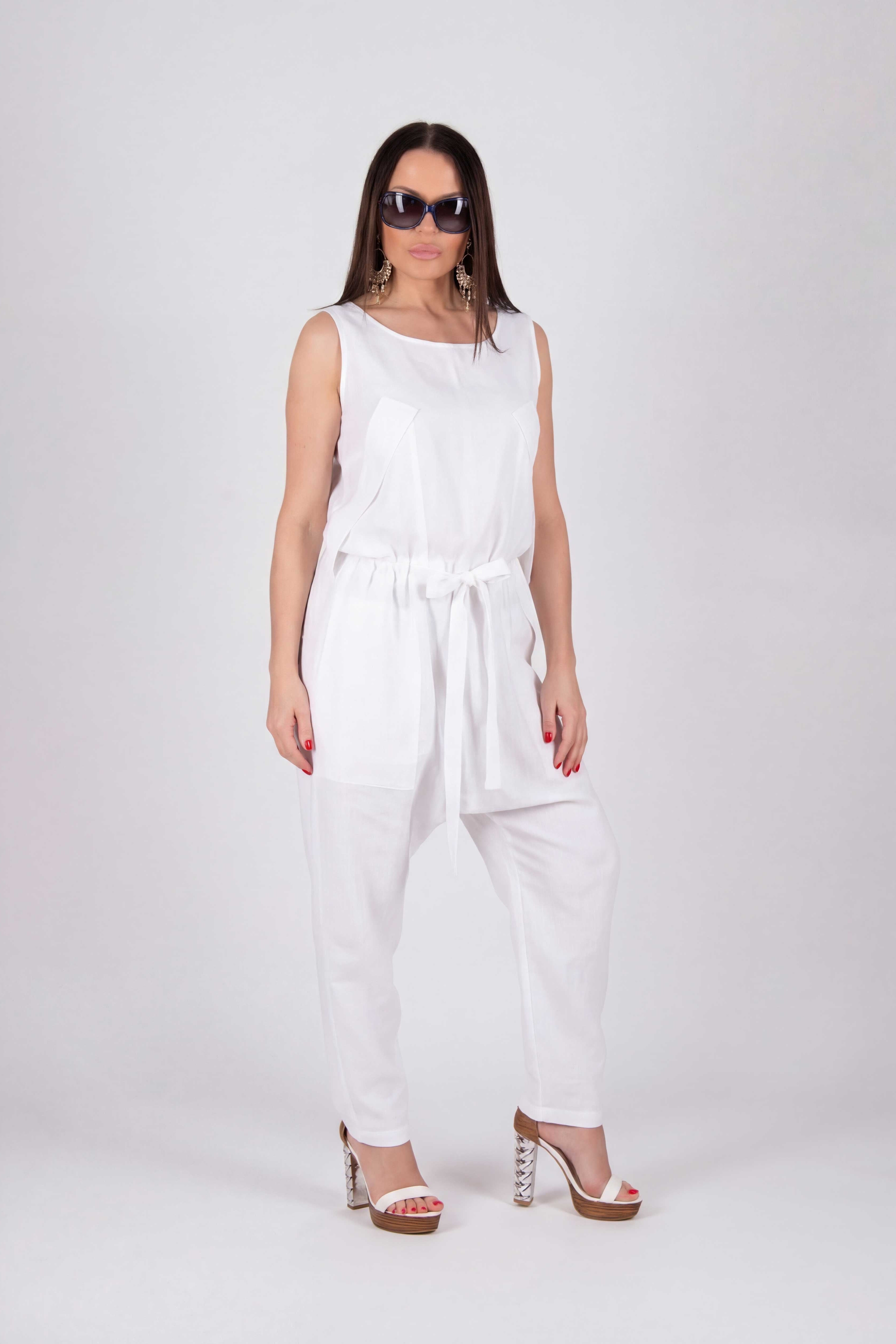 Woman wearing a white sleeveless jumpsuit on a white background