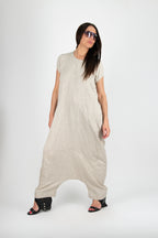 Woman wearing a beige jumpsuit
 with a plain background