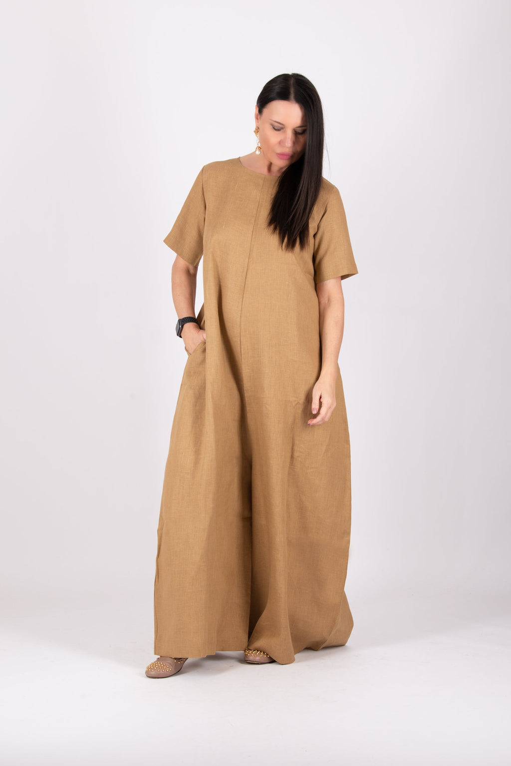Woman wearing a beige jumpsuit on a white background