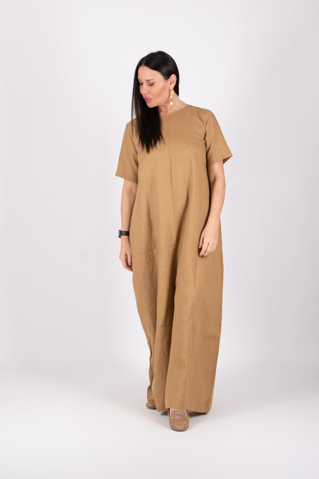 Woman wearing a beige jumpsuit on a white background