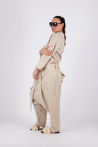 Person wearing a beige suit with sunglasses on a white background