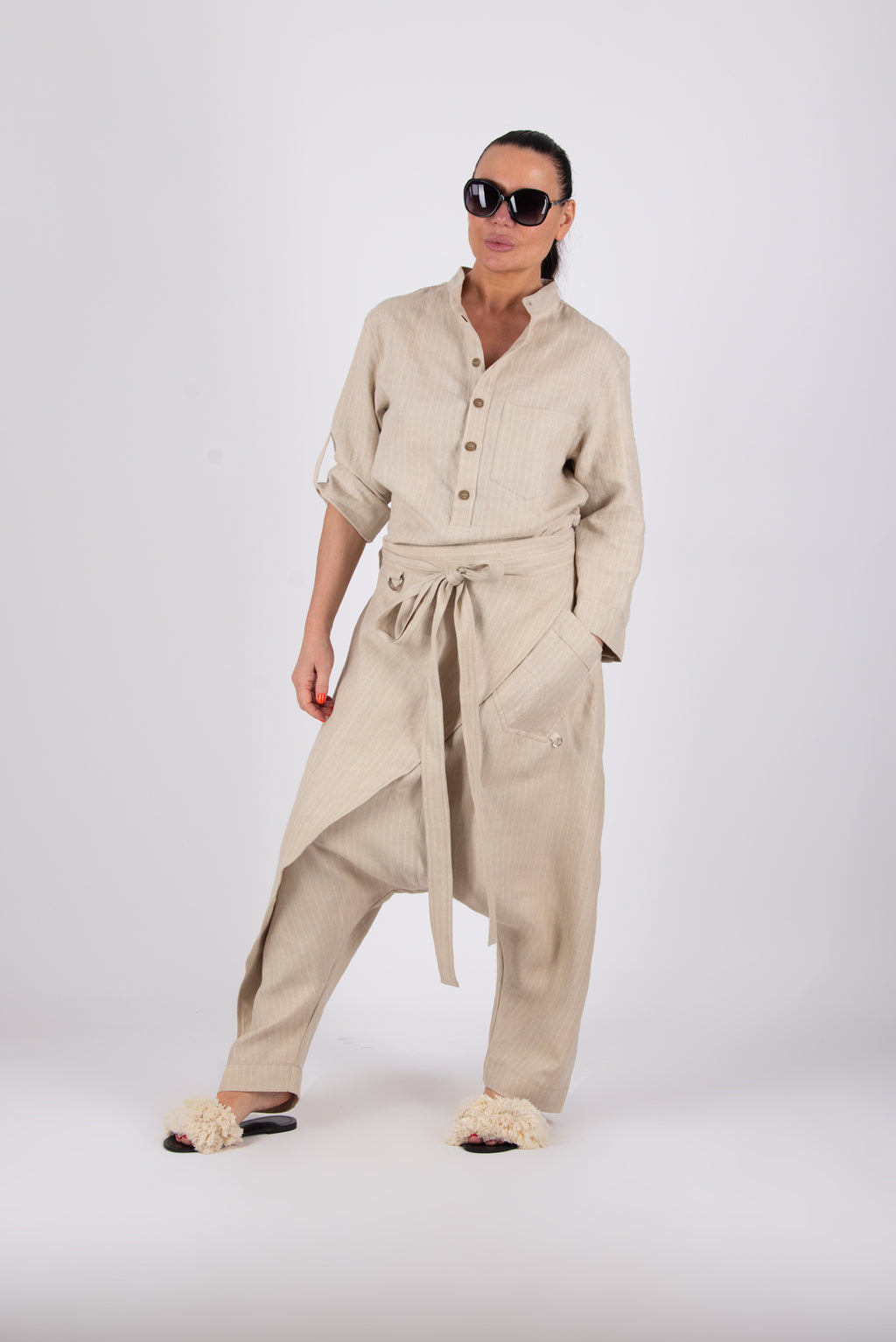 Woman wearing a beige outfit with a shirt and pants on a white background