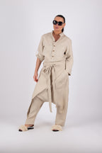 Woman wearing a beige outfit with a shirt and pants on a white background