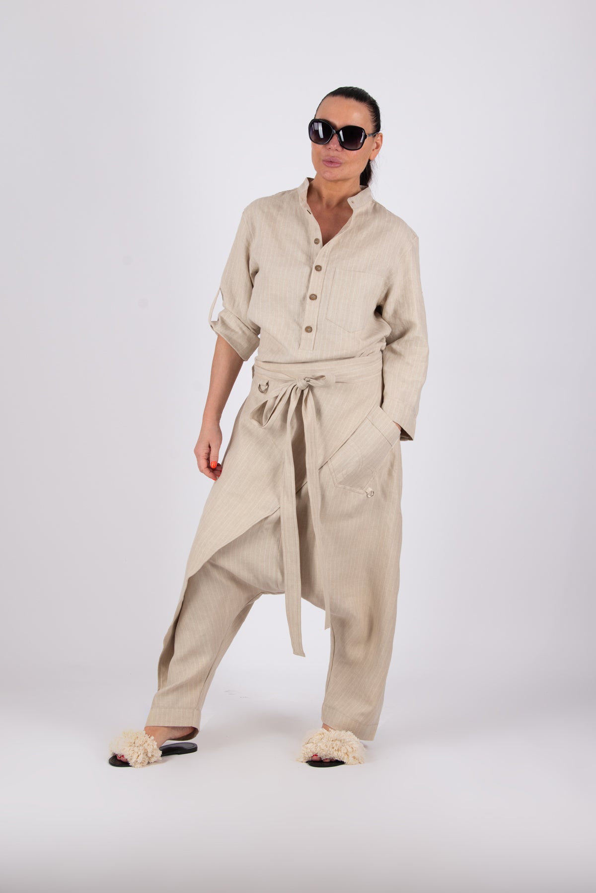 Woman wearing a beige outfit with a shirt and pants on a white background