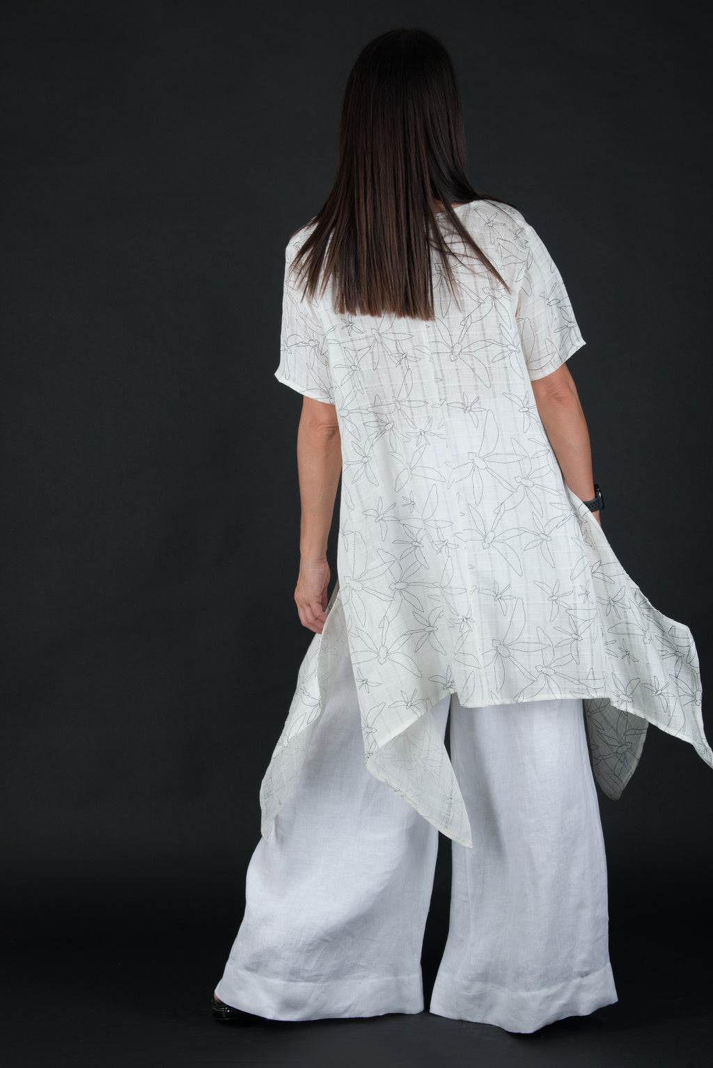 Woman wearing a white outfit with a dark background
