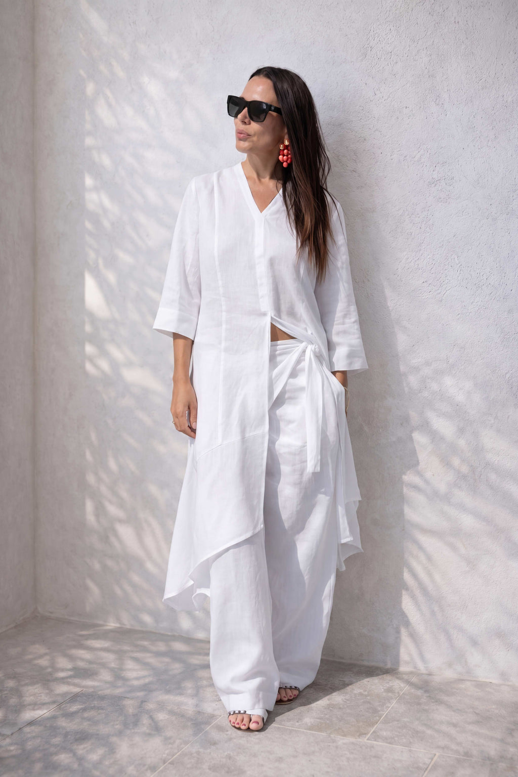 Woman wearing a white outfit against a white wall