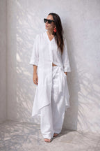 Woman wearing a white outfit against a white wall