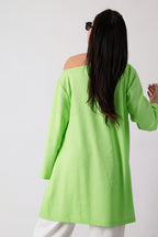 Person wearing a bright green off-shoulder top against a white background