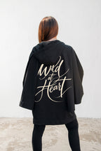 Black hooded poncho sweatshirt - batwing sleeves, snap-fastening pockets and Wild at Heart back print, Melody | EUG Fashion #black
