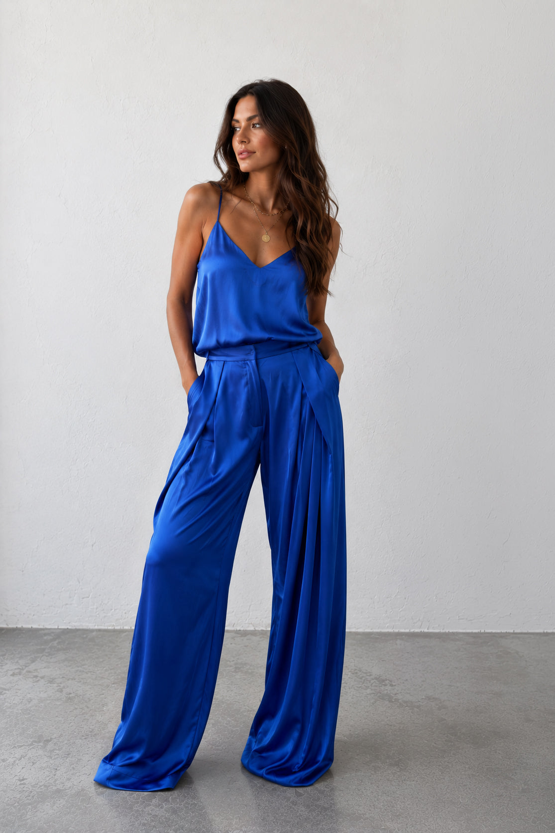 Woman wearing a blue jumpsuit against a plain background