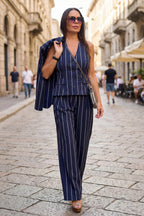 A person wearing navy blue pinstripe trousers 