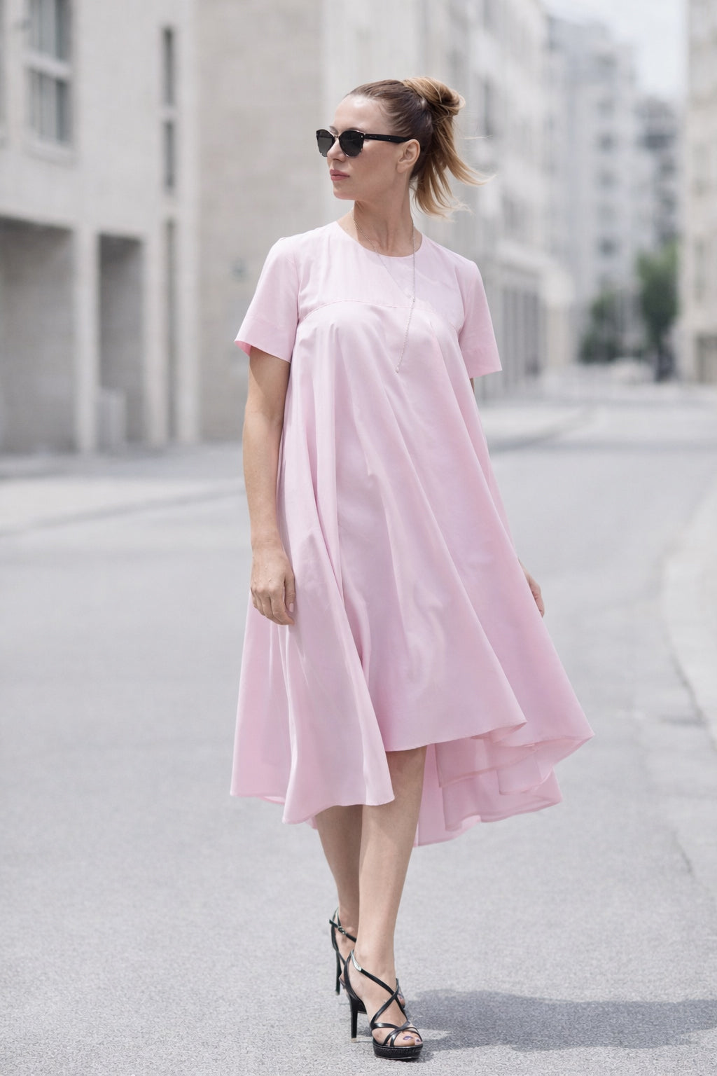 Woman wearing a pink dress on a city street