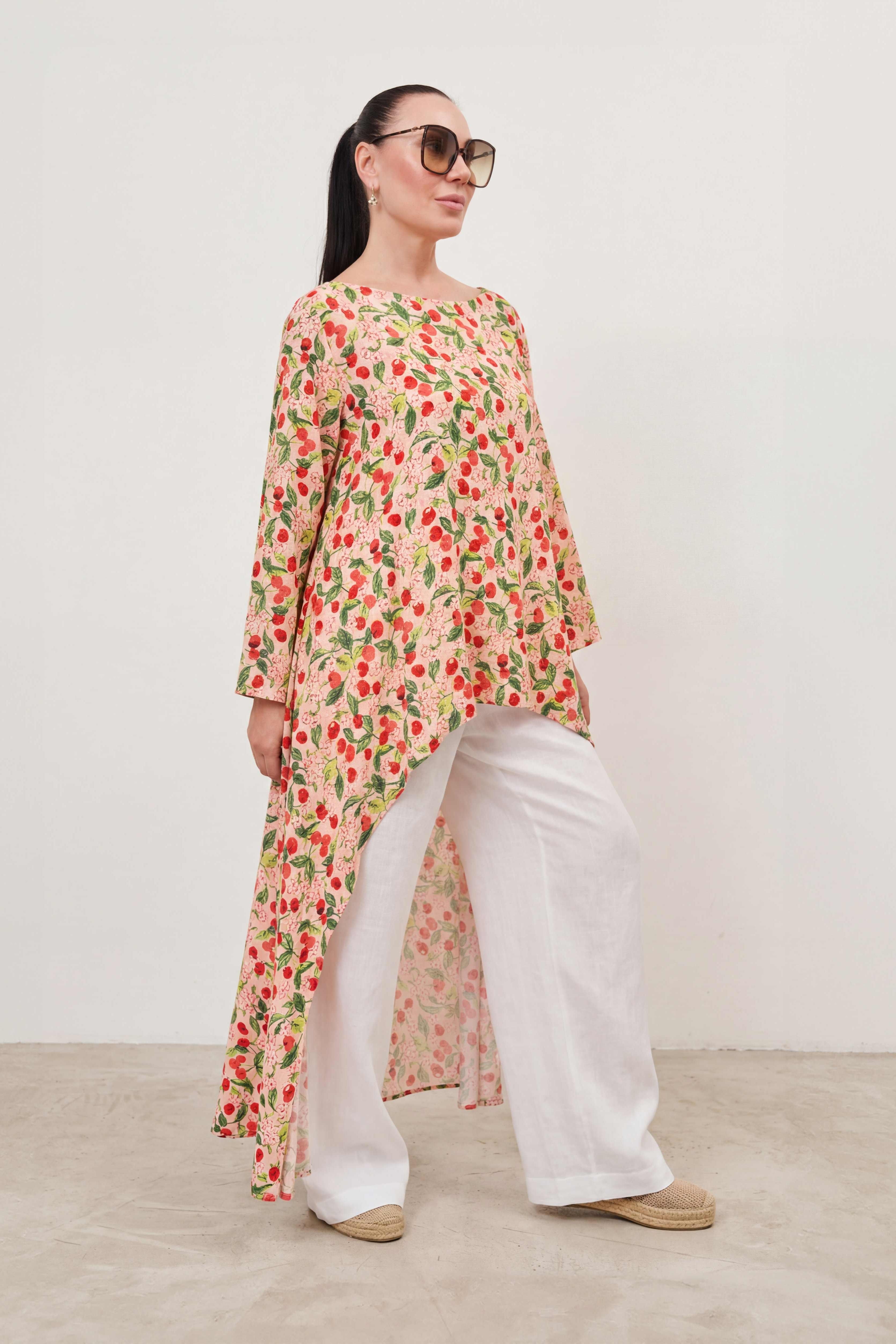 Woman wearing a floral dress and sunglasses against a plain background