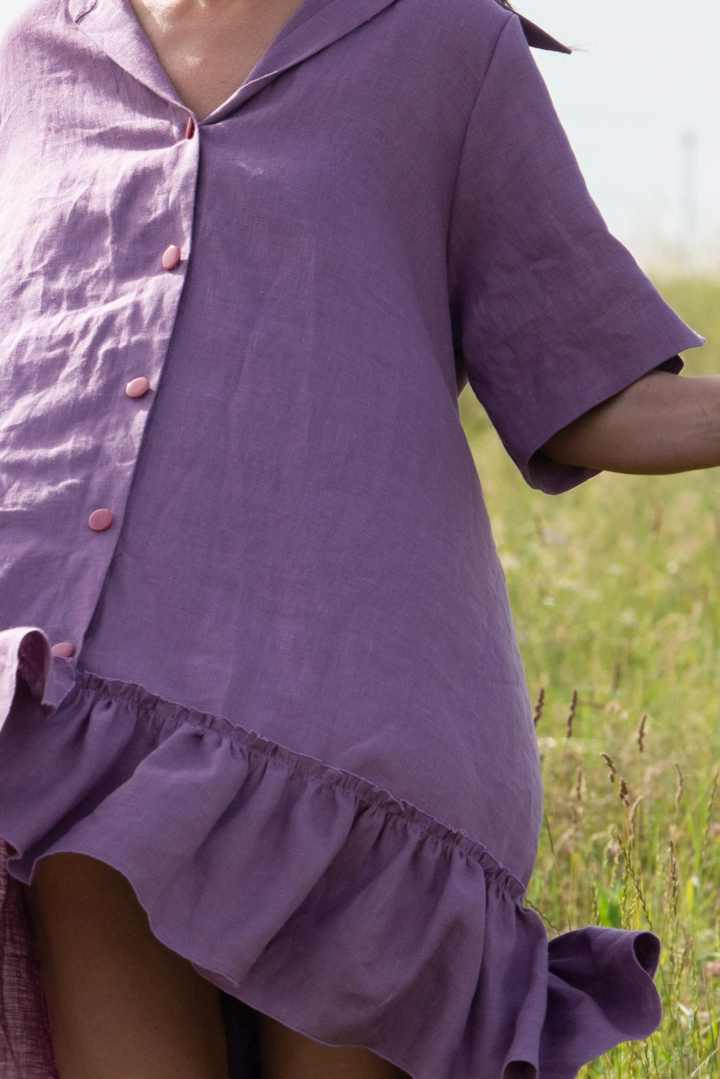 Purple dress with a ruffled skirt worn by a person in a grassy field