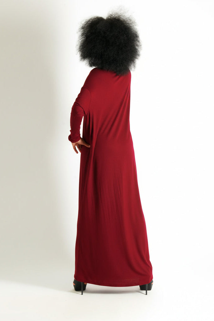 Person wearing a long red dress with a white background