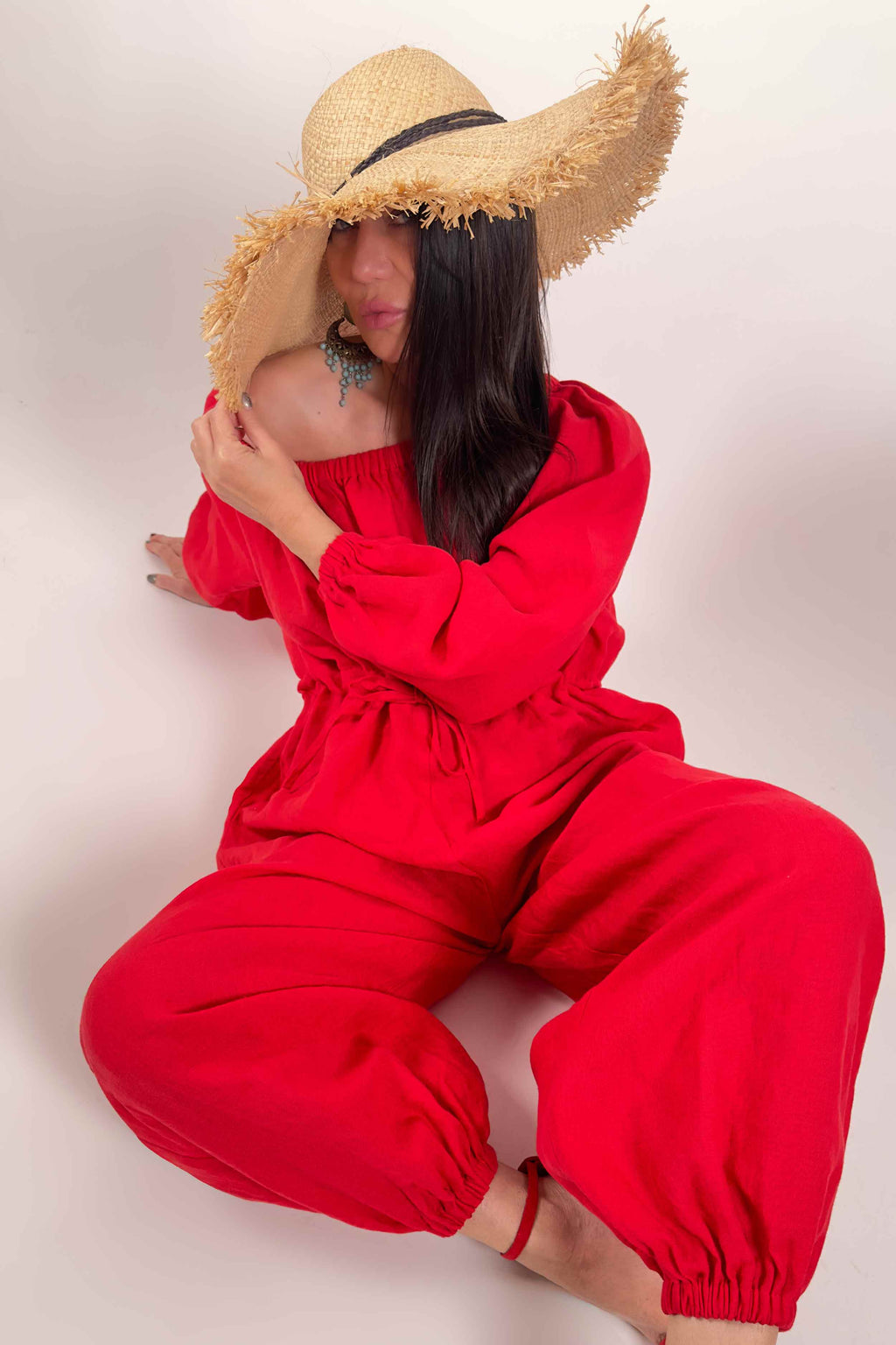 Person wearing a red outfit and straw hat on a plain background