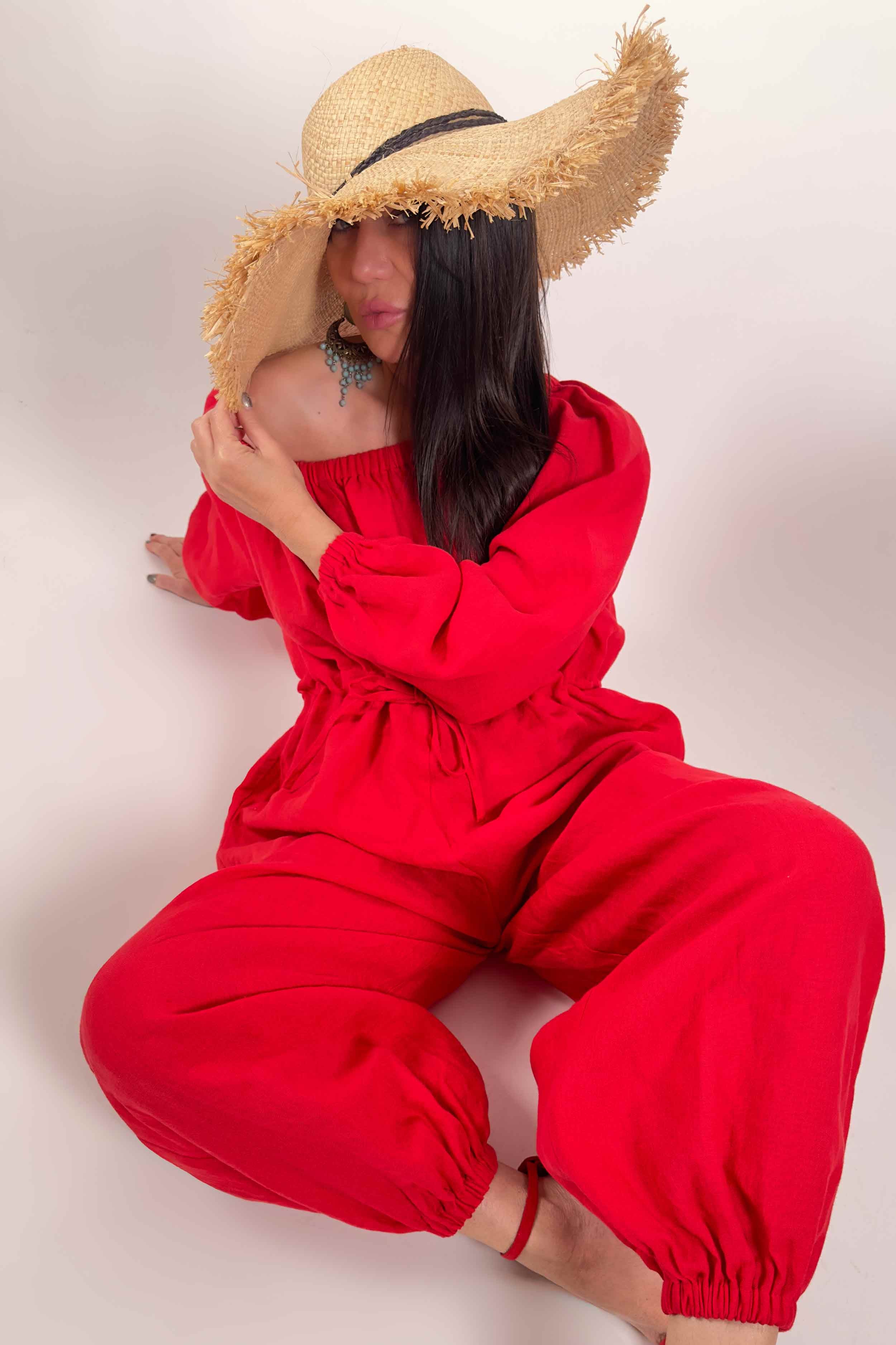 Person wearing a red outfit and straw hat on a plain background