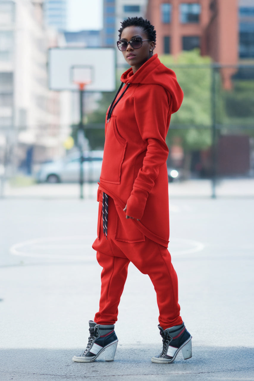 Person wearing a red tracksuit with sunglasses in an urban setting