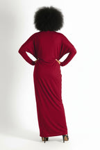 Person wearing a red dress with their back to the camera on a white background