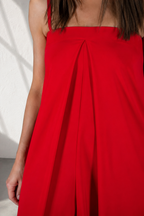 Red jumpsuit with a close-up of the fabric on a neutral background