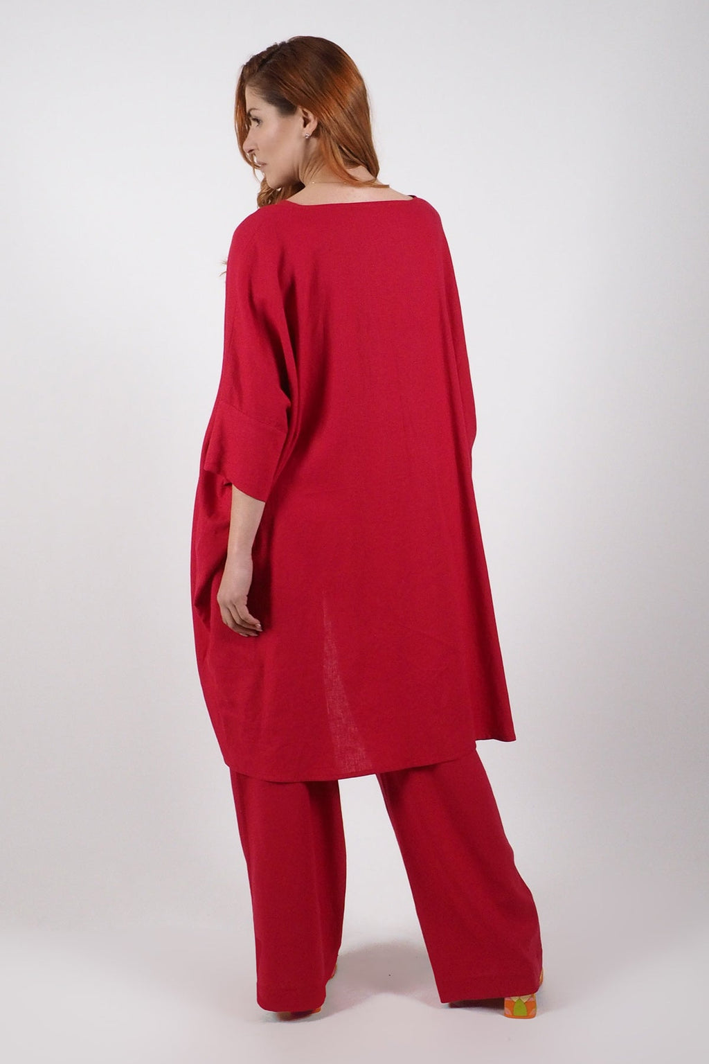 Woman wearing a red linen outfit on a white background