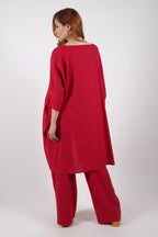 Woman wearing a red linen outfit on a white background