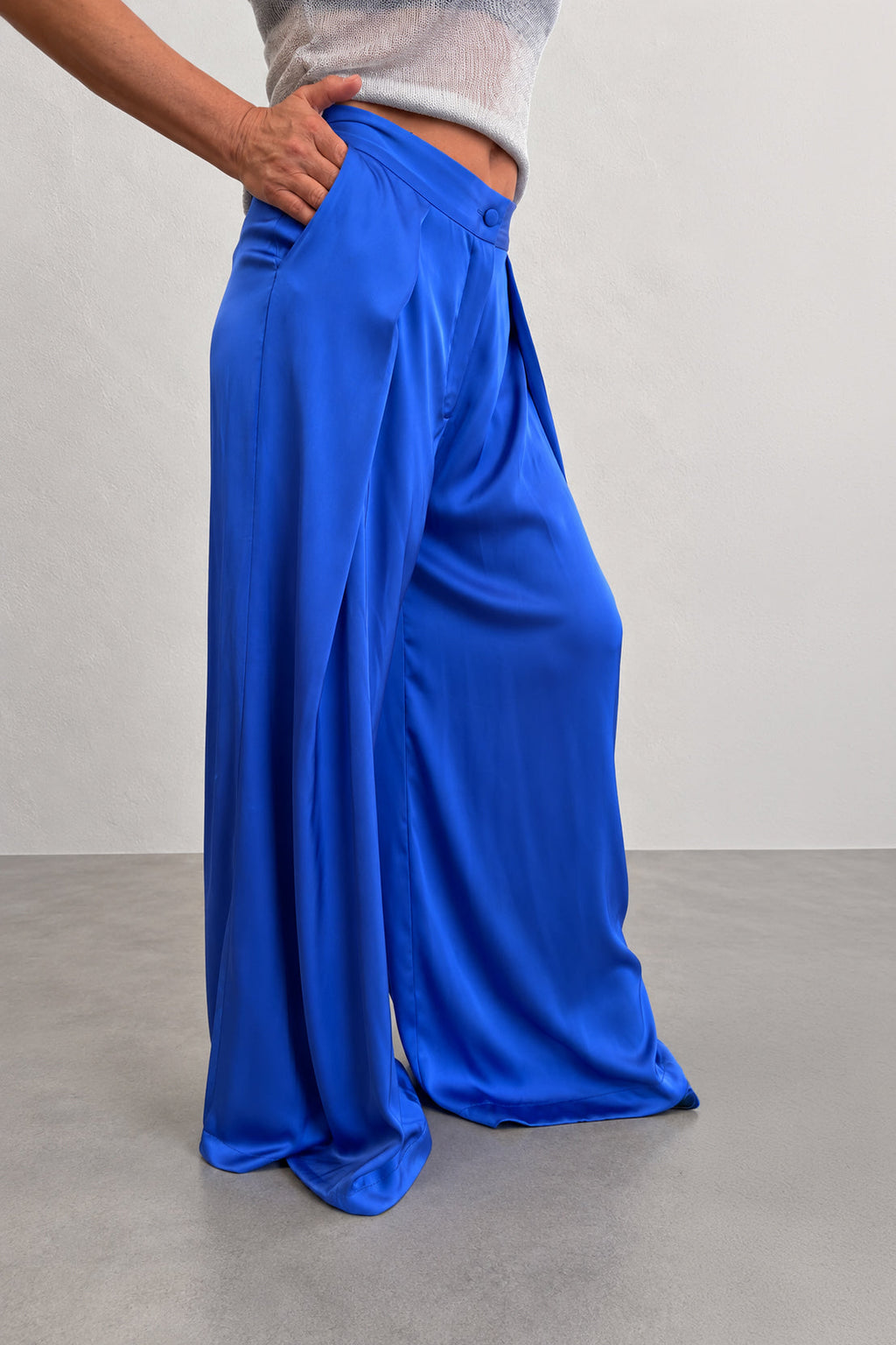 Person wearing blue wide-leg pants on a plain background