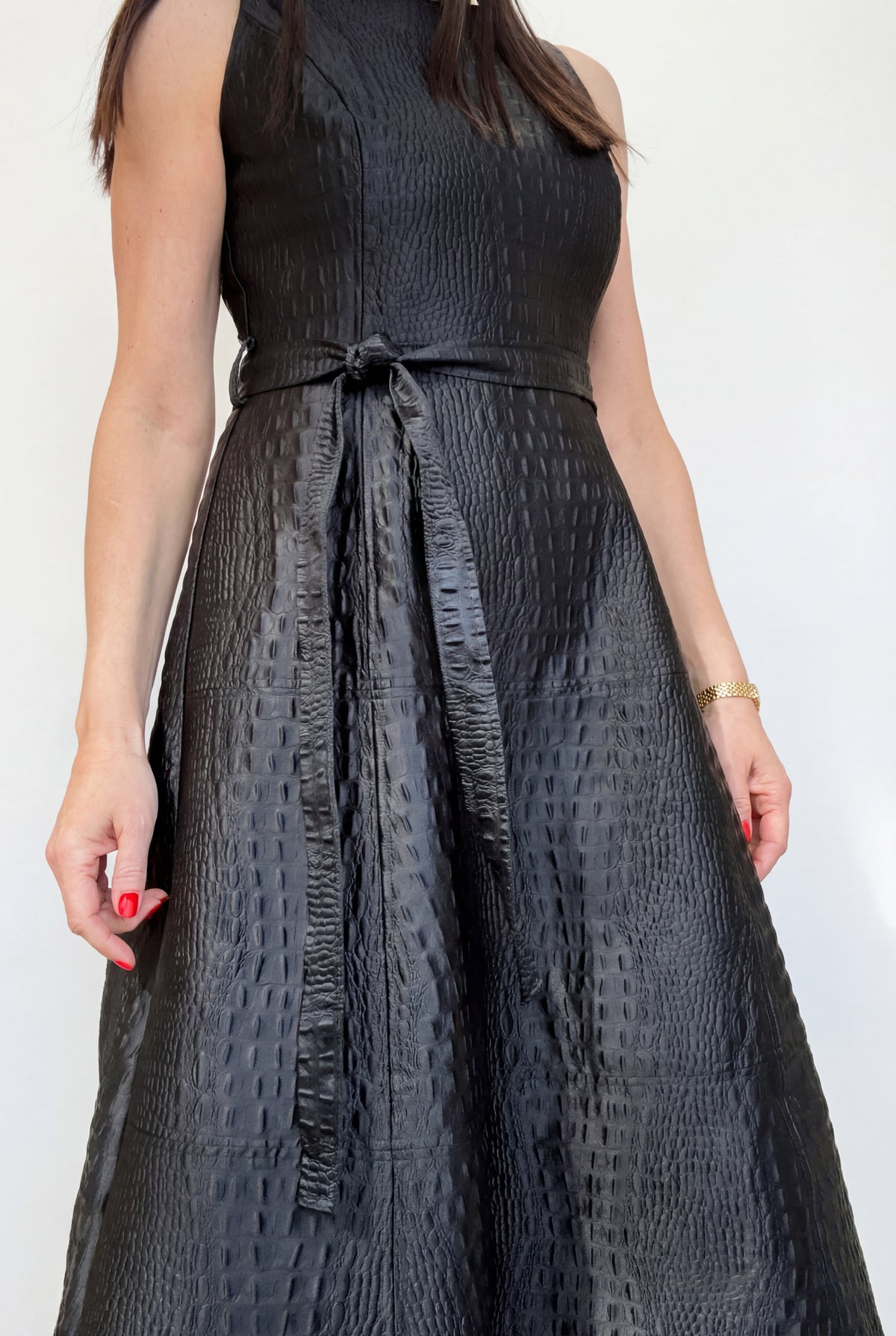 Woman wearing a black patterned dress against a white background