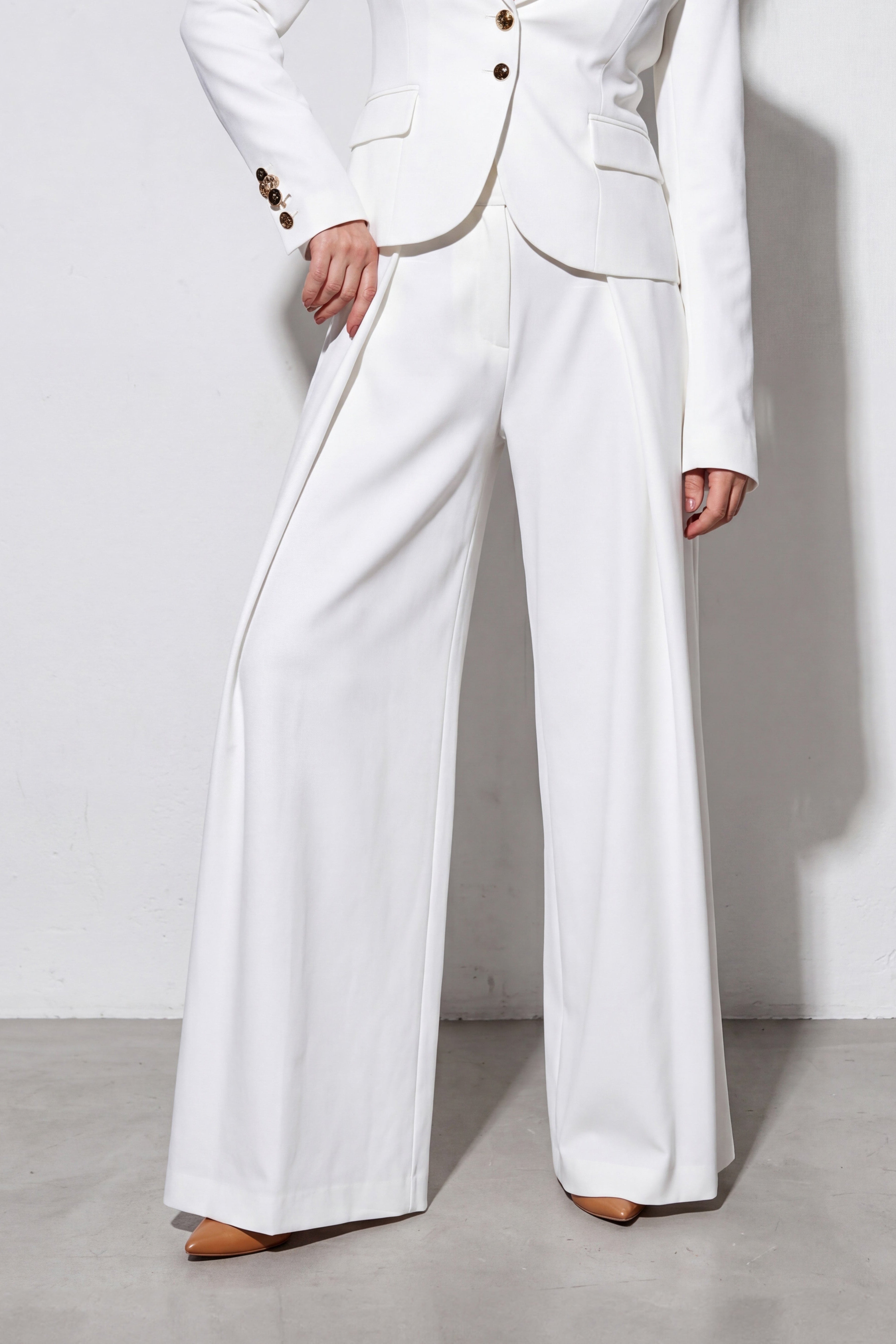 White suit with wide-leg pants on a plain background