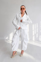 Woman wearing a white outfit in a bright room