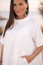 Woman wearing a white dress with a blurred natural background