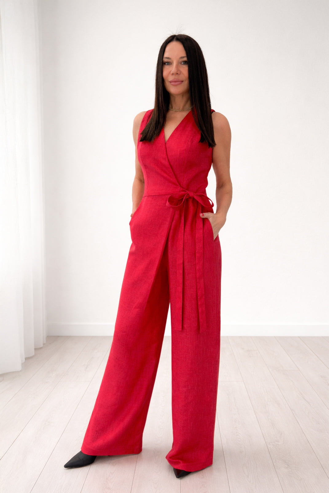 Woman wearing a red jumpsuit against a white background