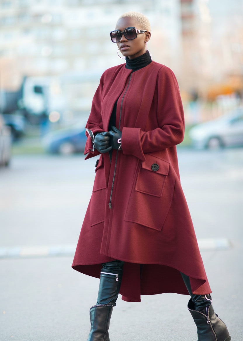 Person wearing a red coat and black boots on a street.
