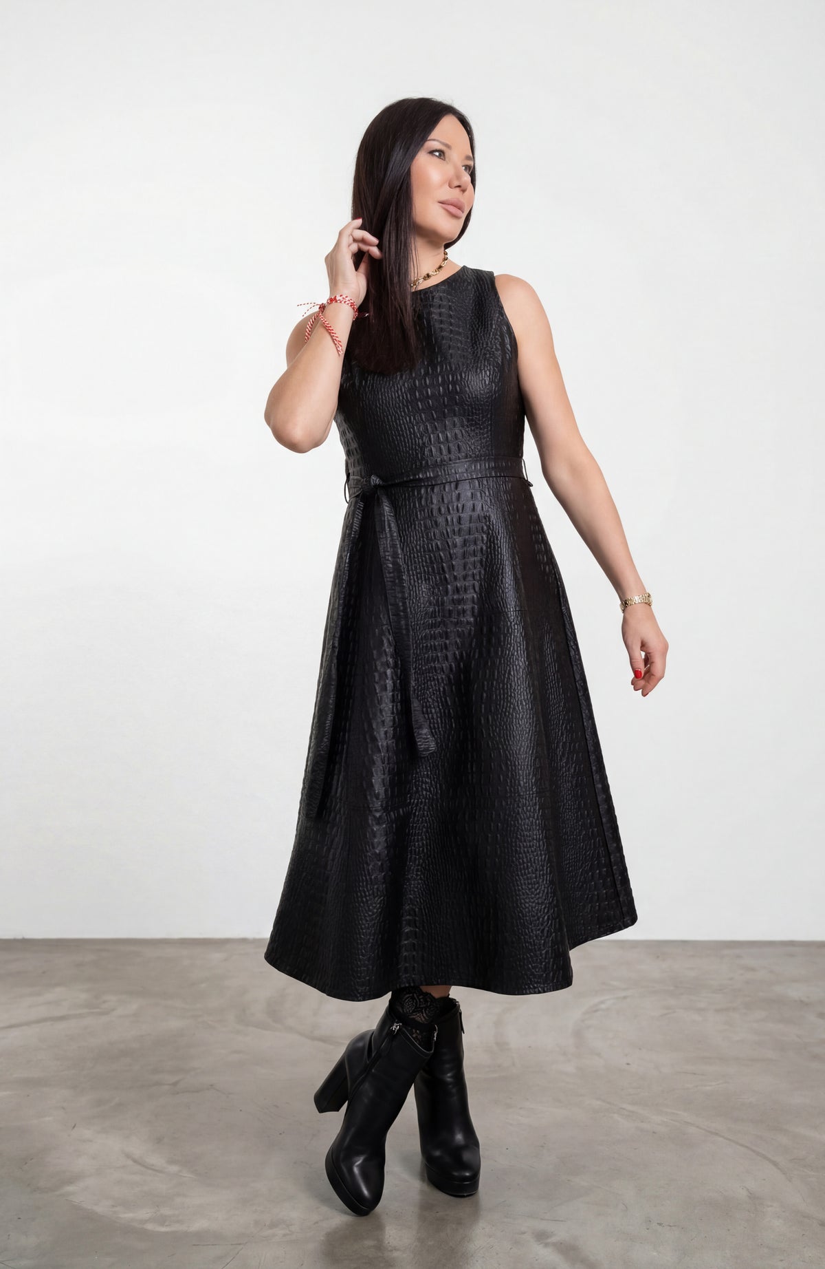 Woman wearing a black dress with a textured pattern on a white background