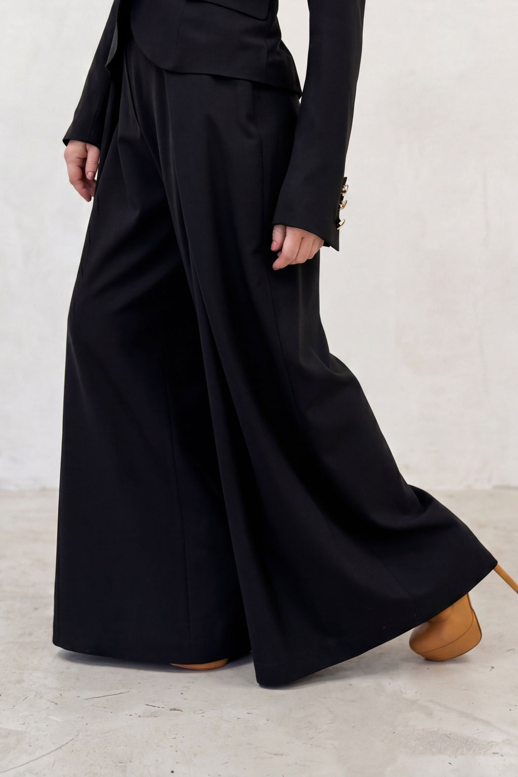 Person wearing a black outfit with a long skirt on a white background