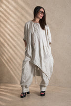 Woman wearing a beige linen outfit with a beige background