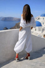 A woman with white wide linen jumpsuit 