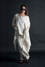 Woman wearing a natural linen outfit against a black background