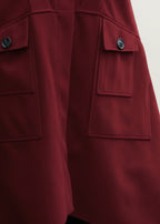 Close-up of a red coat with buttoned pockets on a white background