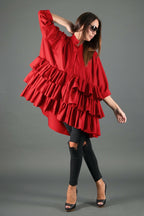 Woman wearing a red ruffled dress on a gray background