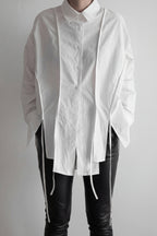 White shirt with long sleeves and black pants on a plain background